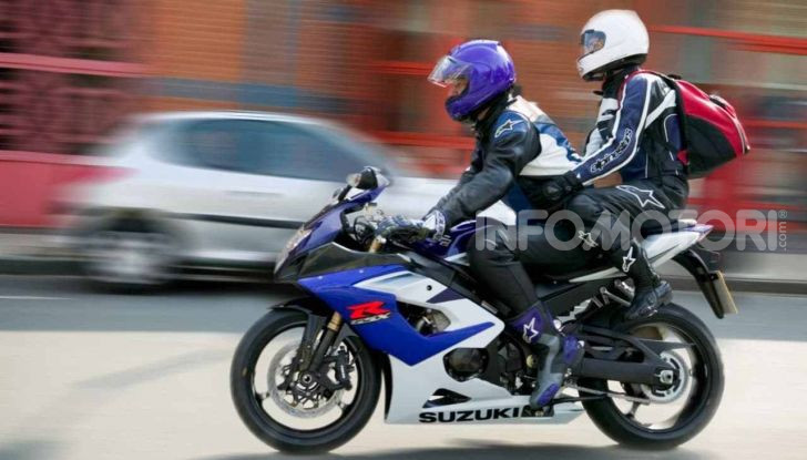 Pilota e passeggero su moto sportiva in strada